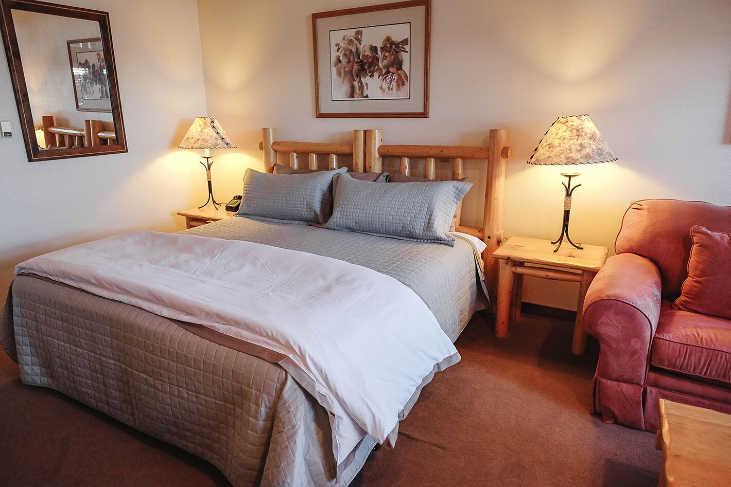 Une chambre à coucher avec un lit, deux tables de chevet, une chaise et un miroir.
