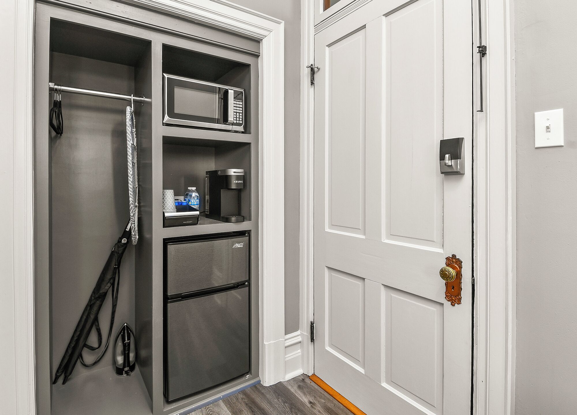 A compact kitchen with a refrigerator, microwave, coffee maker, and a small countertop.