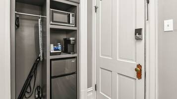 A compact kitchen with a refrigerator, microwave, coffee maker, and a small countertop.