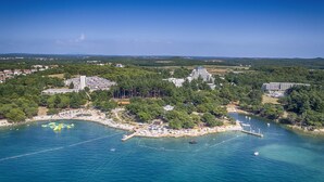 An aerial view of a coastal area with a marina, several buildings, and a beach. - Sunny Porec Residence (Porec)