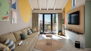 A modern living room with a sofa, a round table, a ceiling fan, and a TV mounted on the wall.