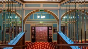 A grand staircase with a red patterned carpet leading to a bookshop. - The Metropole Hotel (Blackpool)
