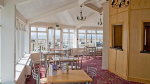 A restaurant with high ceilings, large windows, and a patterned carpet. Tables and chairs are arranged for dining. - The Metropole Hotel (Blackpool)