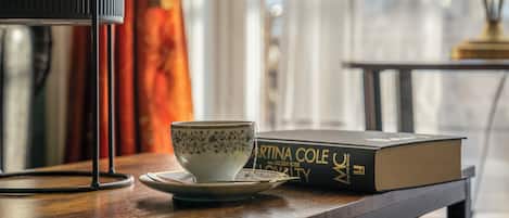 A table with a cup, saucer, and a book titled "Martina Cole UK".