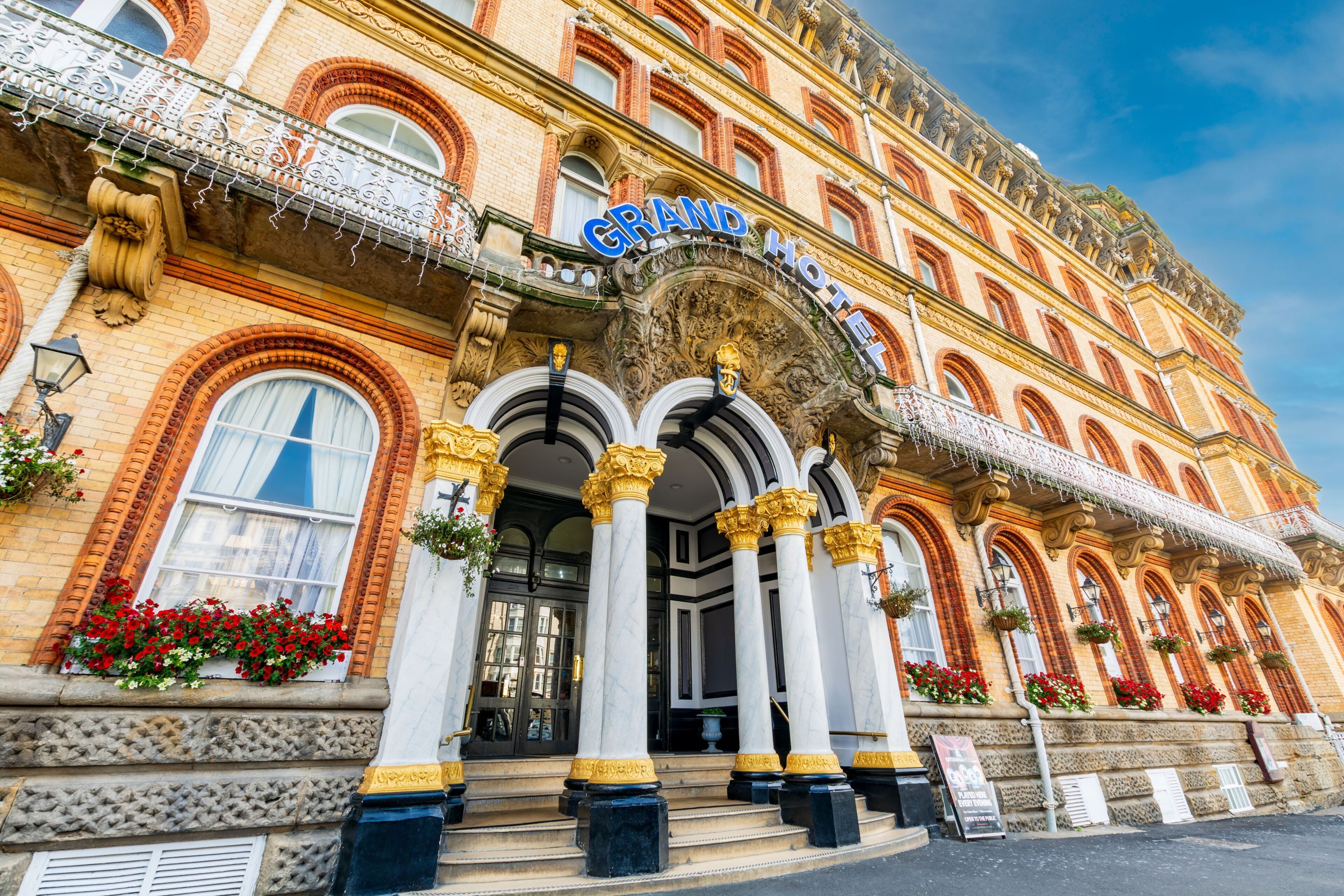 Un hotel imponente con arquitectura ornamentada, amplias columnas y una entrada destacada.