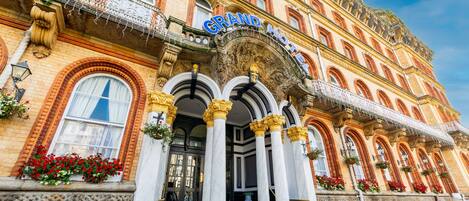 A grand hotel with ornate architecture, large columns, and a prominent entrance.