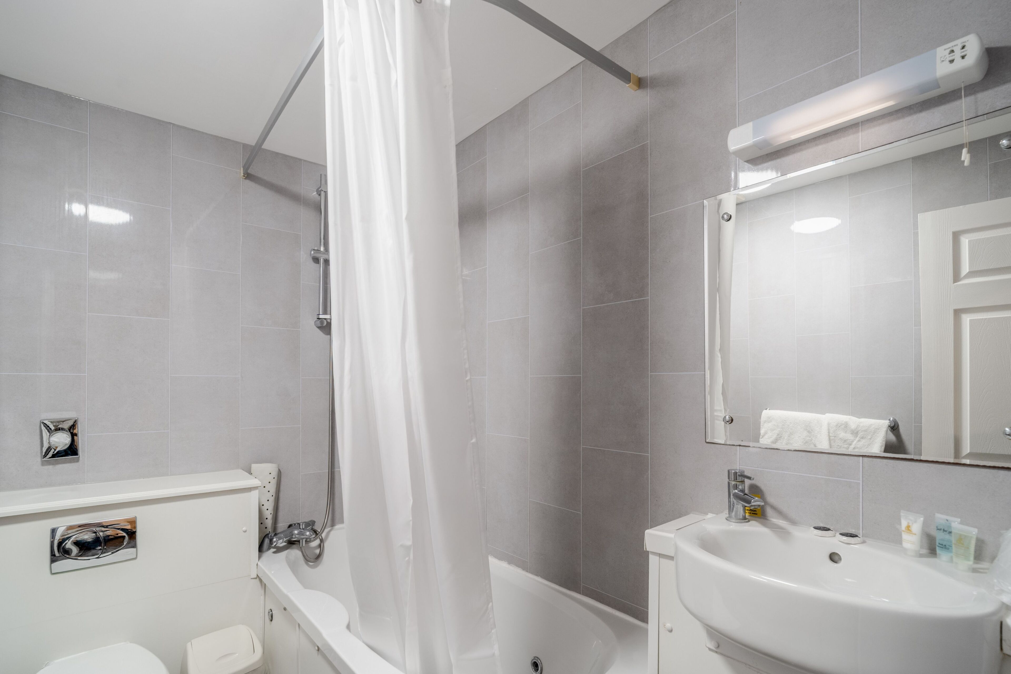 A modern bathroom with a bathtub, a sink, and a toilet.