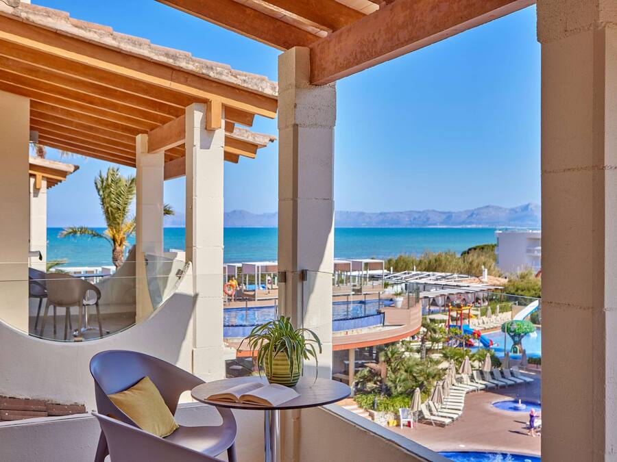 Un balcón con vista a una piscina y al mar.