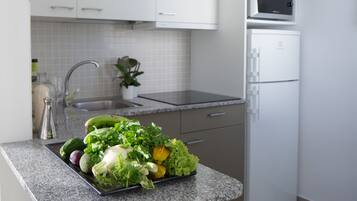 A kitchen with a granite countertop, a sink, and a microwave.
