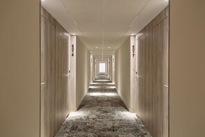 A long, narrow hallway with wooden doors on both sides, each labeled with numbers. - Hotel Best Oasis Tropical (Mojacar)