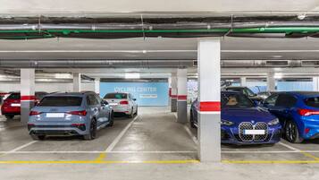 A multi-level parking garage with several cars parked, including an Audi and a BMW.