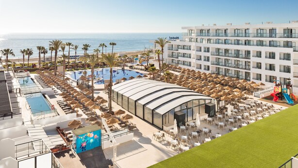 Un hotel con piscina, zona de estar y vistas a la playa.
