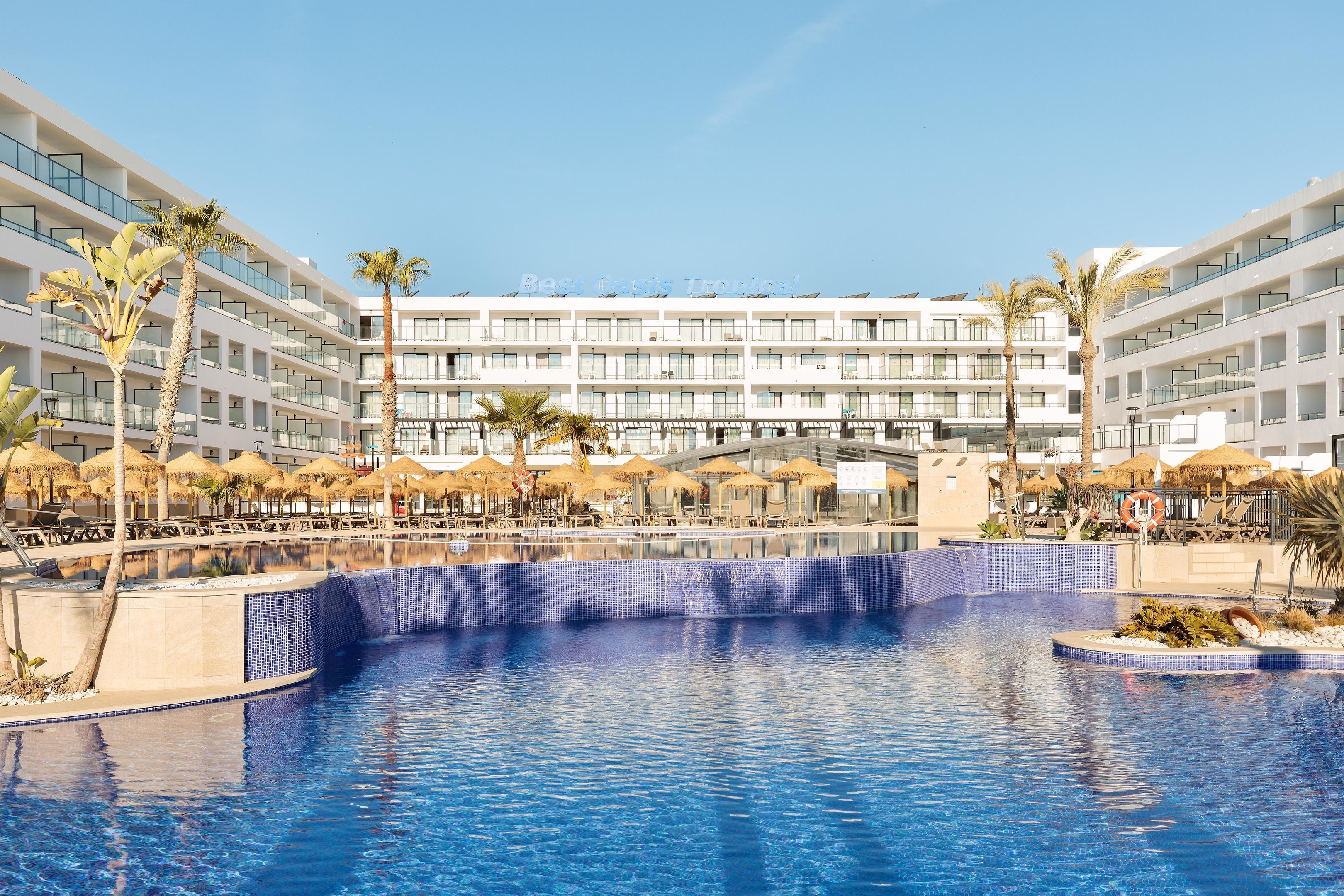 Een binnenzwembad, een buitenzwembad, parasols voor strand/zwembad