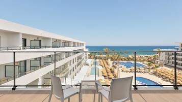 Un balcón de hotel con vistas a una piscina y la playa.