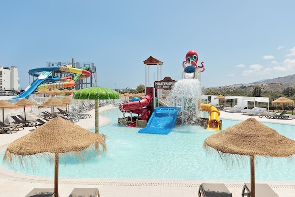 Een binnenzwembad, een buitenzwembad en parasols bij het zwembad