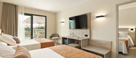 Une chambre d’hôtel avec deux lits, une télévision, un bureau et un grand miroir.