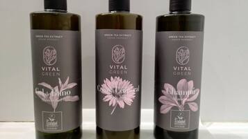 Tres botellas de productos Vital Green sobre un estante blanco.