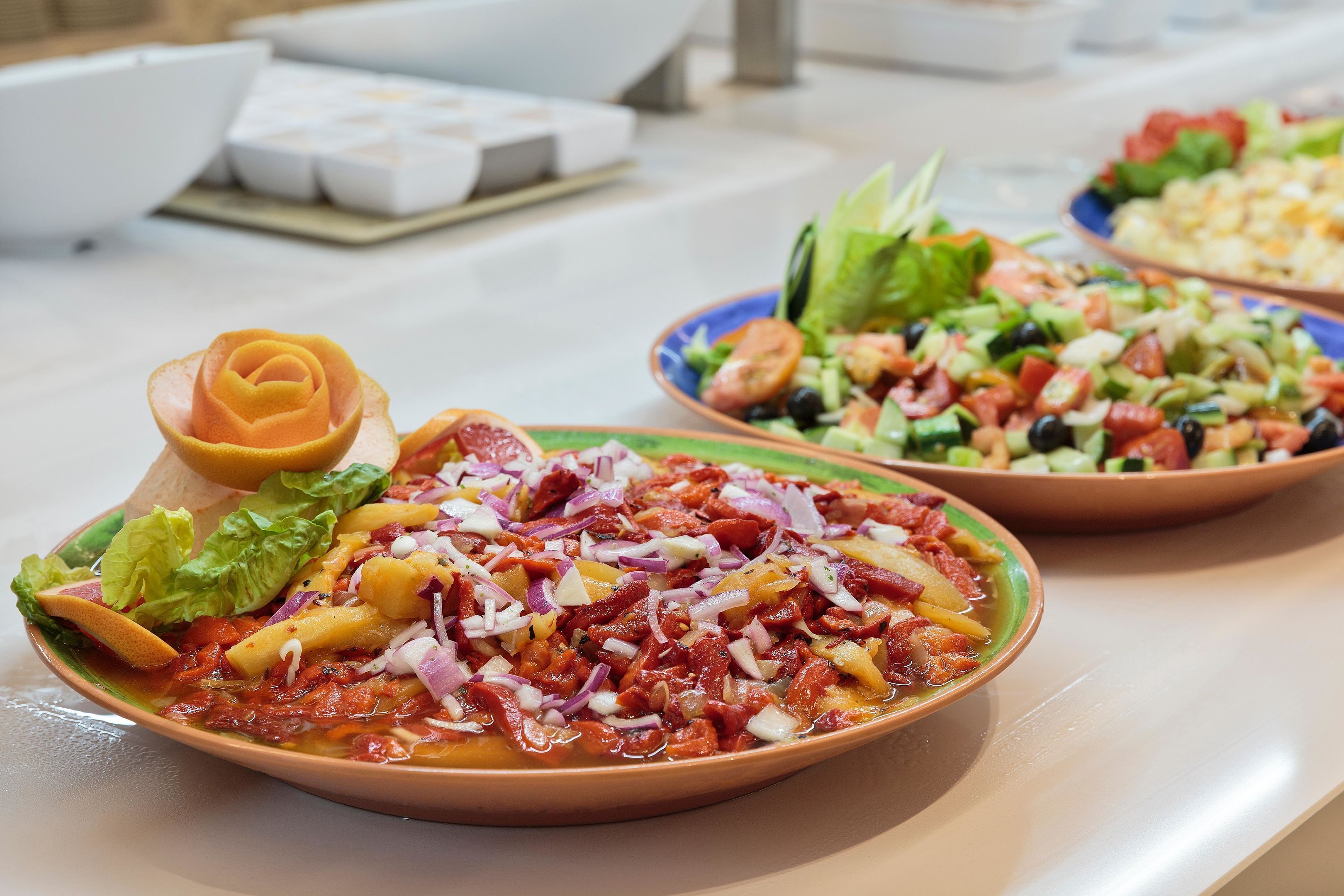 Une table où l’on trouve différents plats, notamment une salade, une pizza et un bol de soupe.