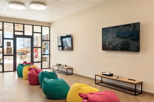 Un intérieur moderne avec des fauteuils en forme de poire, un tableau et un téléviseur accroché au mur.