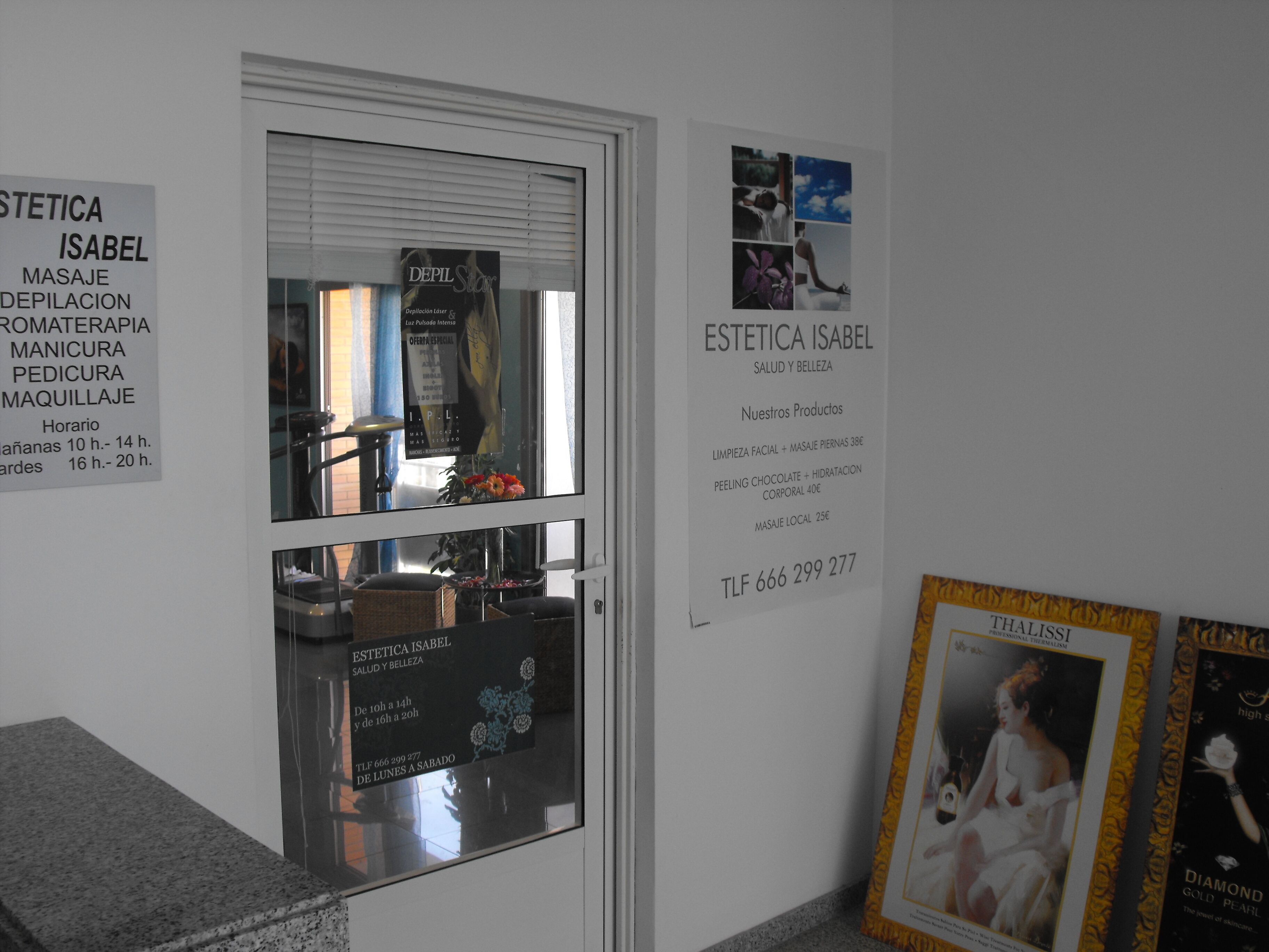 Un interior de salón con una puerta de cristal, un cartel en la pared y un cuadro enmarco.