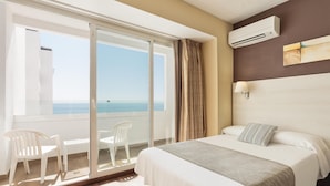 A hotel room with a bed, a view of the sea, a balcony with chairs, and an air conditioning unit. - Hotel Best Indalo (Mojacar)