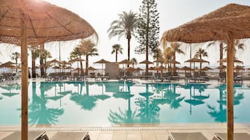 Een buitenzwembad, parasols voor strand/zwembad