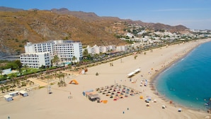 A coastal hotel with multiple floors, a beach in the foreground, and mountainous terrain in the background. - Hotel Best Indalo (Mojacar)