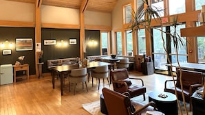 A spacious dining area with wooden floors, high ceilings, and large windows. - Minnewaska Lodge (Gardiner)