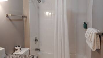 A bathroom with a shower, toilet, and sink.