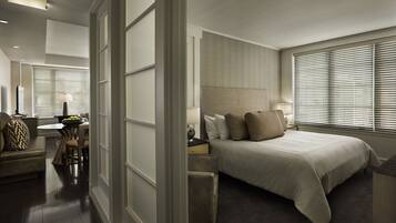 A modern hotel room with a large bed, a desk, and a seating area.