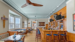 A spacious bar area with wooden bar stools and a long counter. There are multiple seating areas with tables and chairs. - Windsor Hotel, an Ascend Collection Hotel (Americus)