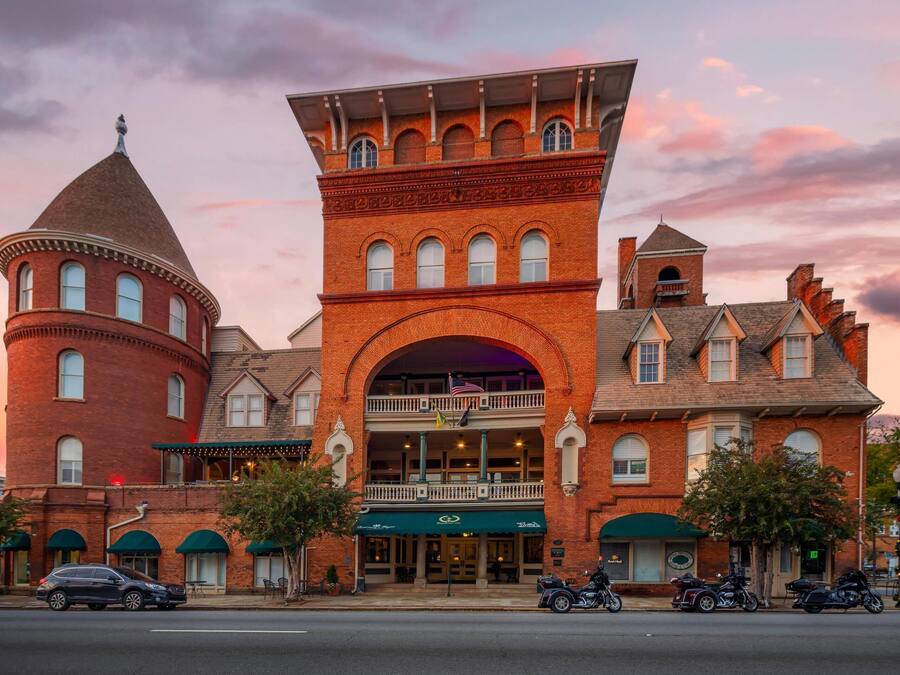 A historic building with a prominent tower, a large central archway, and a balcony.