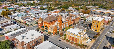 An aerial view of a town with historic buildings, a main street, and surrounding greenery.