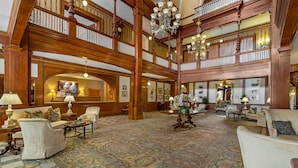A grand lobby with high wooden ceilings, chandeliers, and a large patterned carpet. - Windsor Hotel, an Ascend Collection Hotel (Americus)