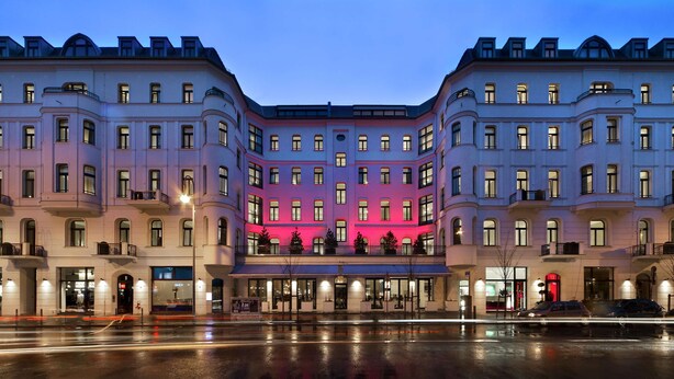 A multi-story hotel with a central pink-lit facade, large windows, and a wet street in the foreground. - Lux 11 Berlin Mitte (Berlin)