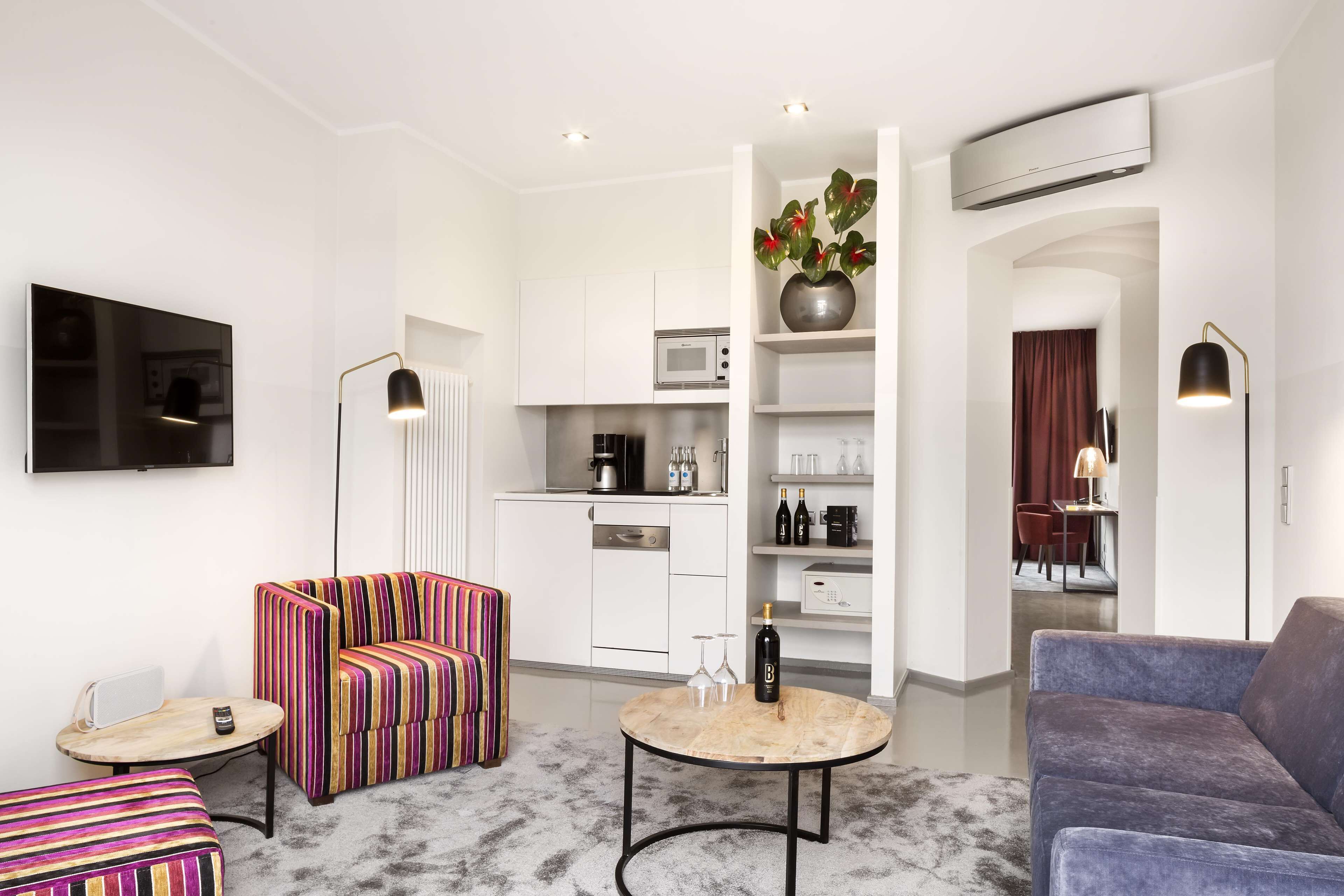 Una sala de estar moderna con sofá, sillón, mesa de centro y televisor de pantalla plana.