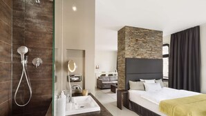 A modern hotel room with a shower, a sink, a bed, and a small seating area. - Lux 11 Berlin Mitte (Berlin)