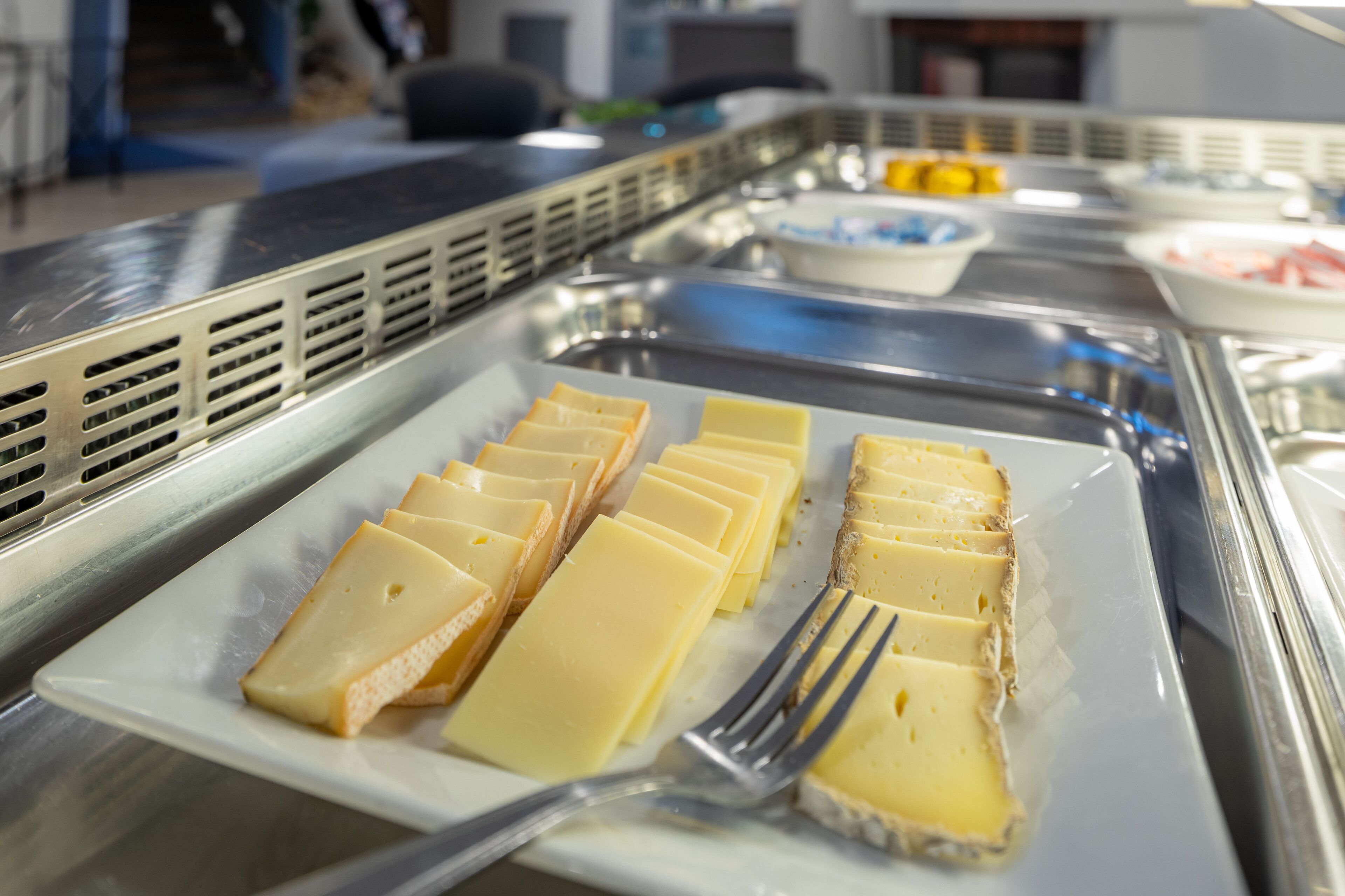 Buffet amb diverses platelles, incloent formatge i altres plats.
