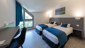 Una habitación de hotel con dos camas, un escritorio y una silla.