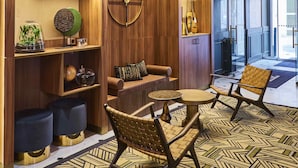 Ein modernes Interieur mit Holzbögen, einem Globus, einer Uhr und einer Sitzecke mit einem gemusterten Teppich.
