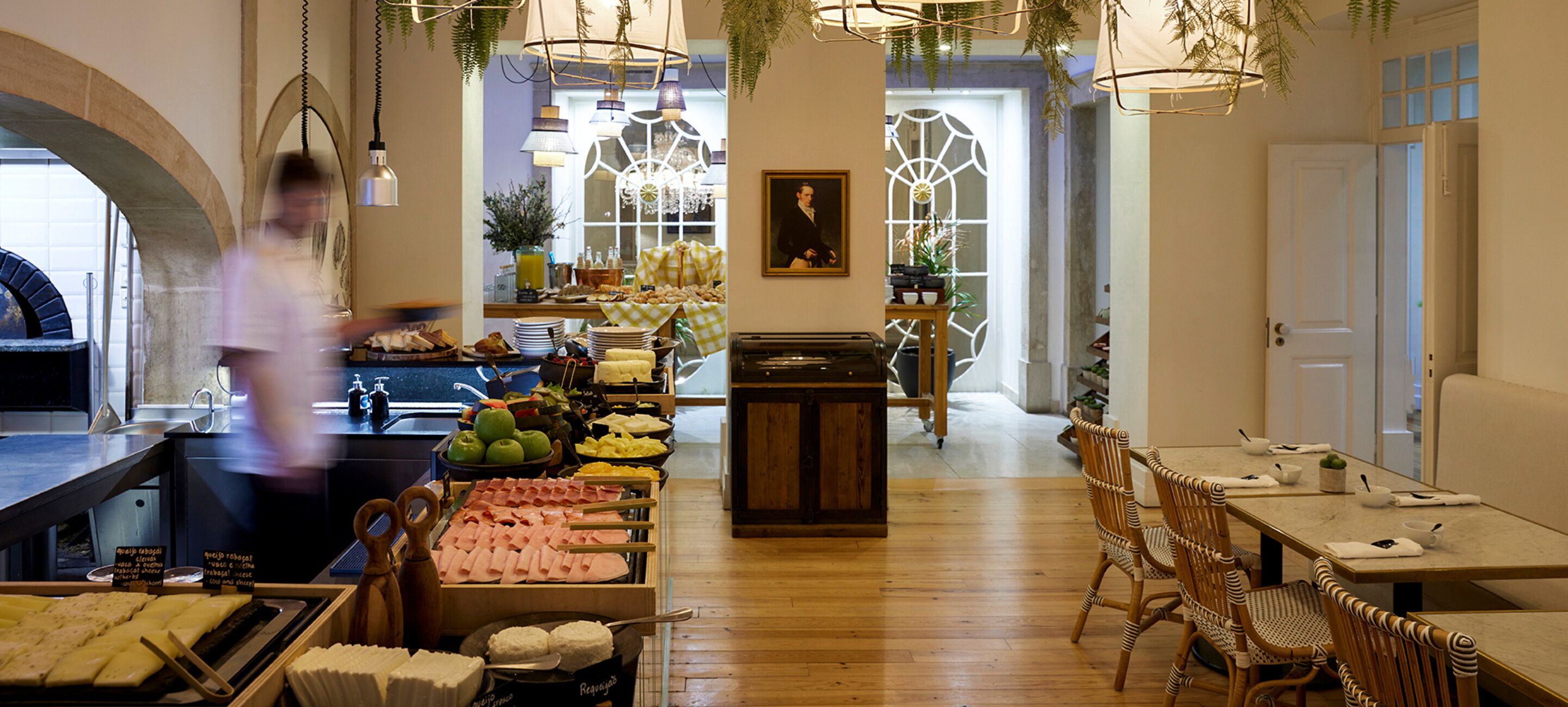 A restaurant with a wooden interior, a buffet with various food items, and hanging lights.