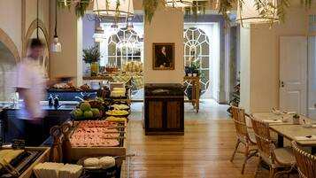 A restaurant with a wooden interior, a buffet with various food items, and hanging lights.