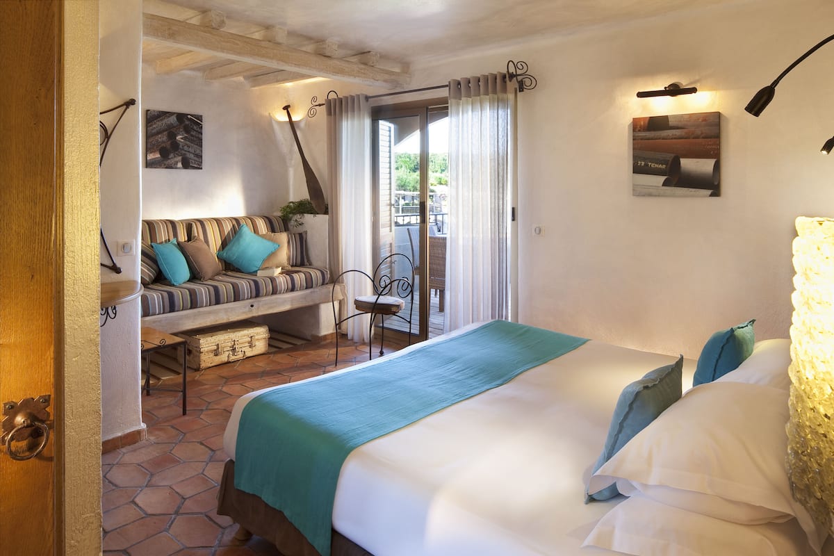 Un dormitorio con cama, sofá y vista al exterior.