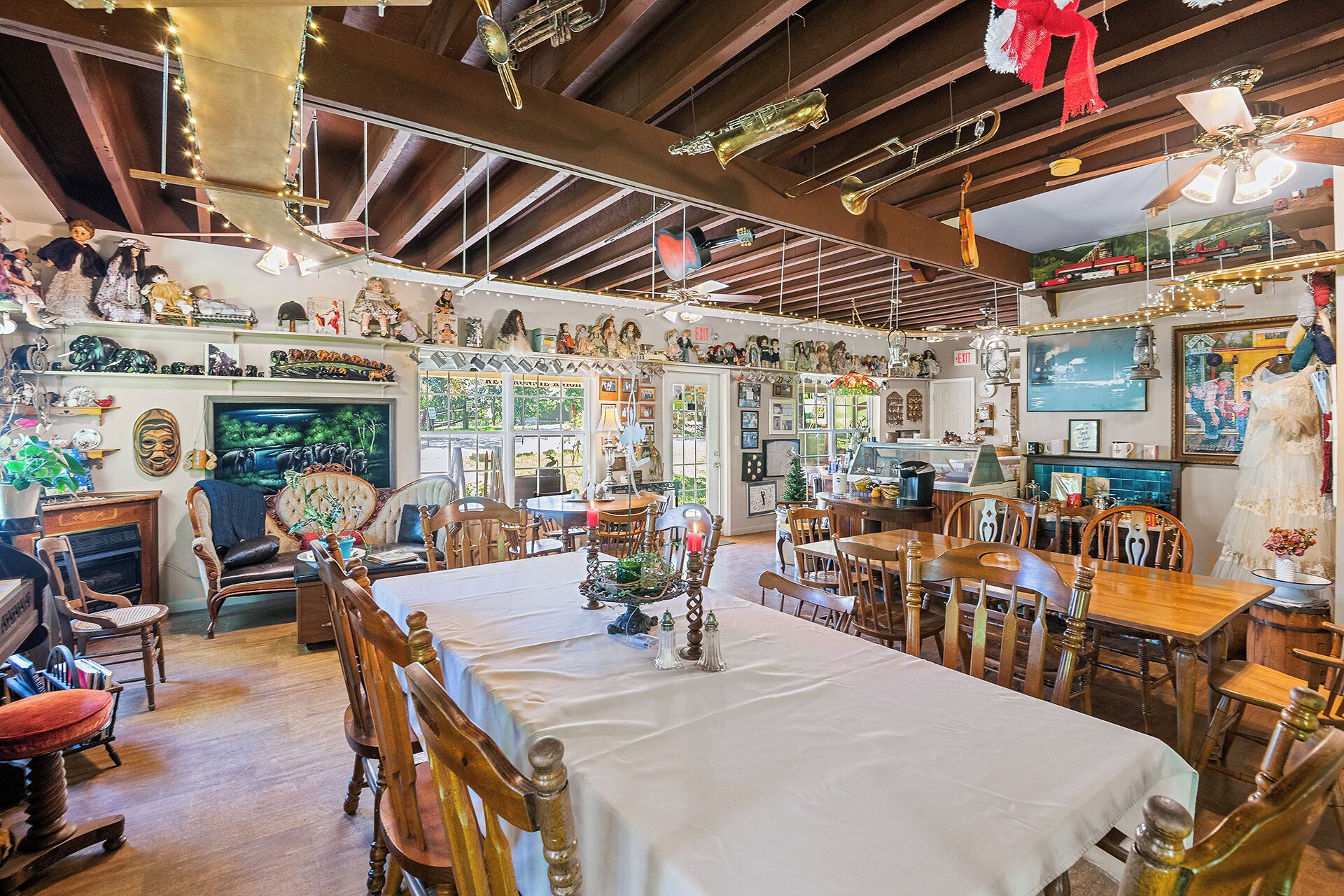 A dining area with a large table, chairs, and various decorative items.