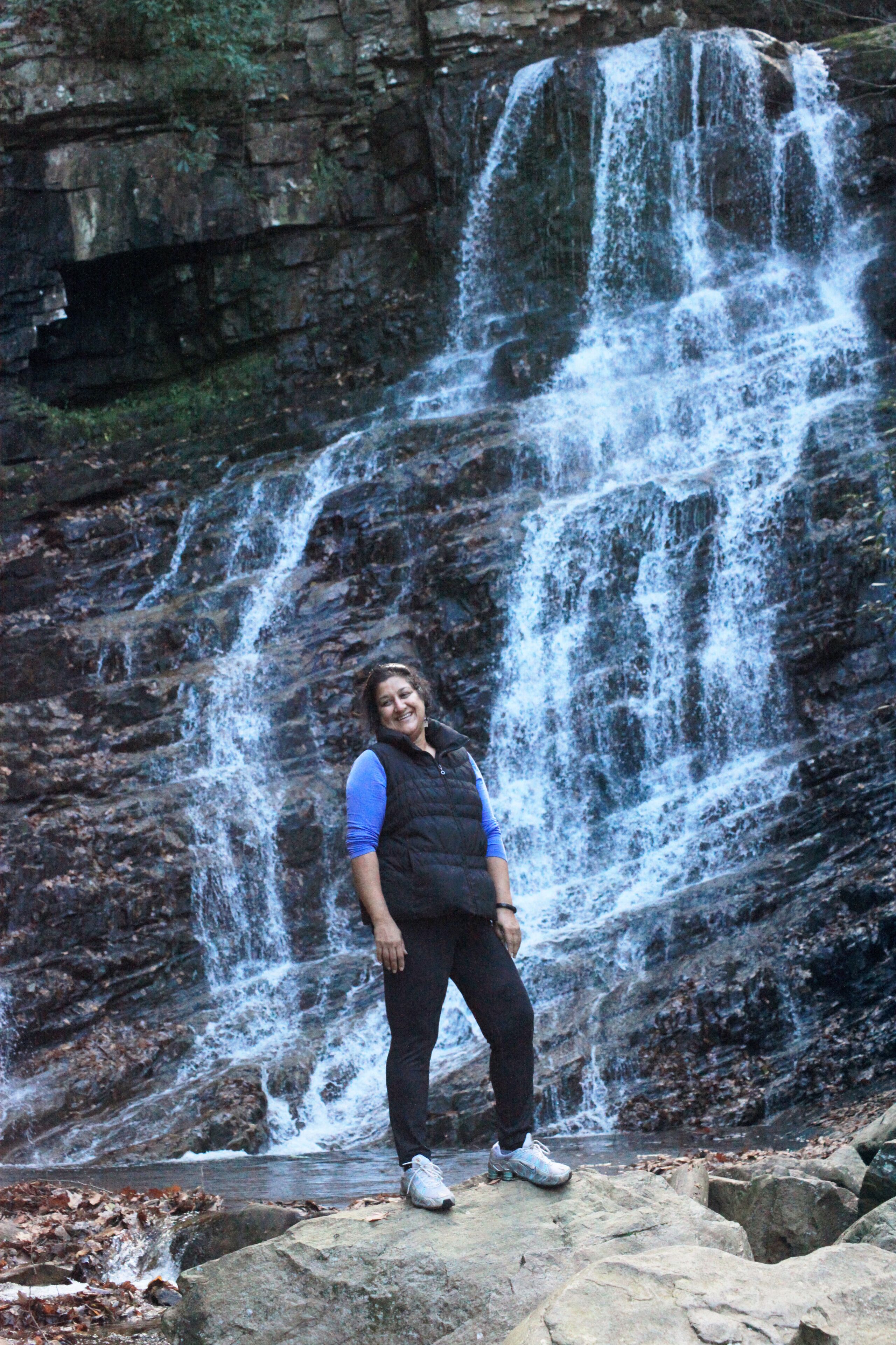 A person standing in front of a waterfall.