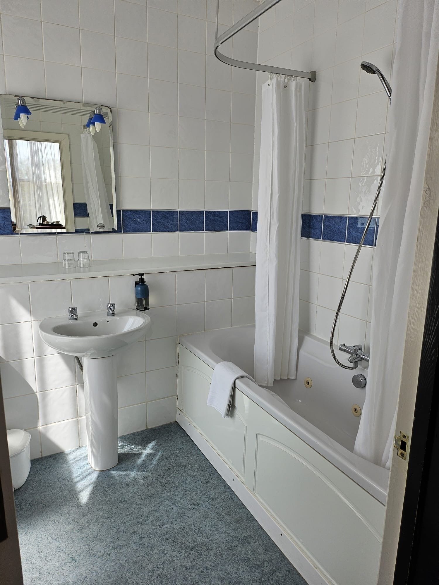 Un baño con lavamanos blanco, bañera y ducha.