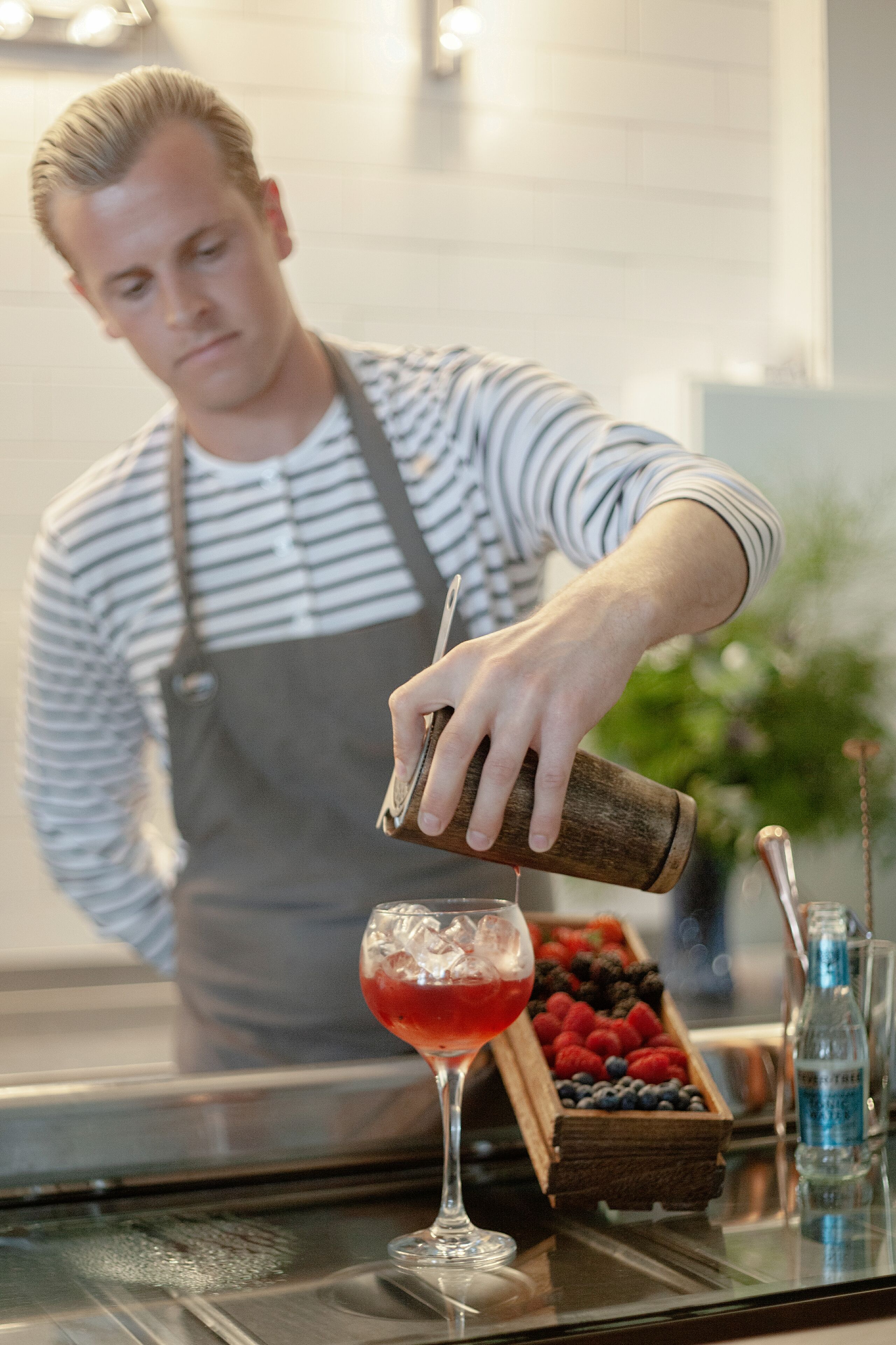 Un barman verse une boisson dans un verre.