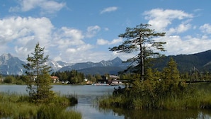 A lake with surrounding trees and mountains in the background. - Alpina (SEEFELD IN TIROL)
