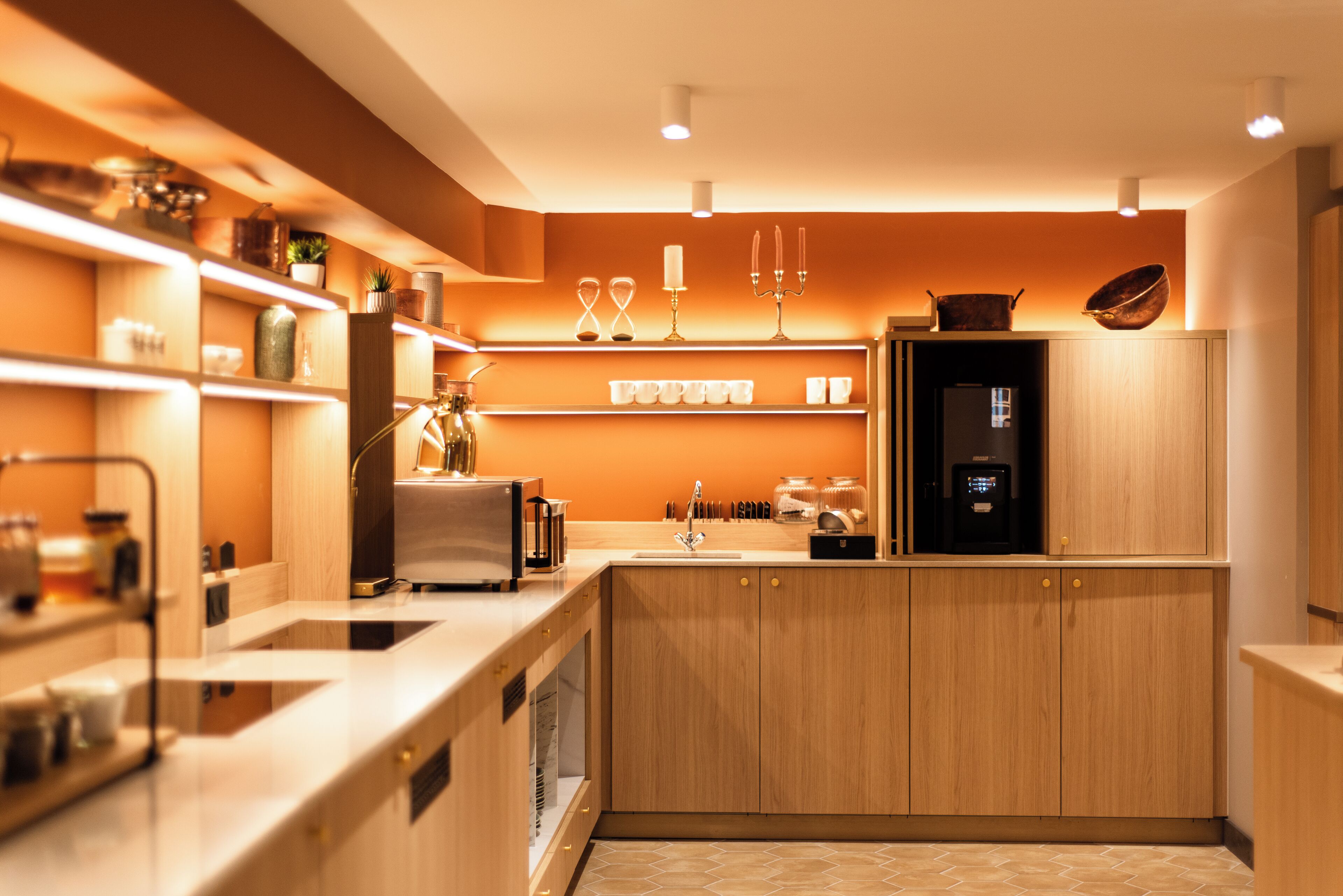 Una cocina moderna con armarios de madera, horno empotrado y cafetera.