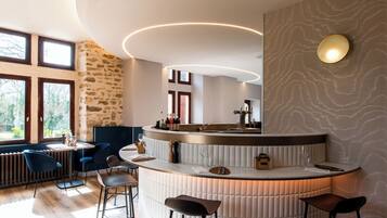 A modern kitchen with a curved island, bar stools, and a view of the outdoors.